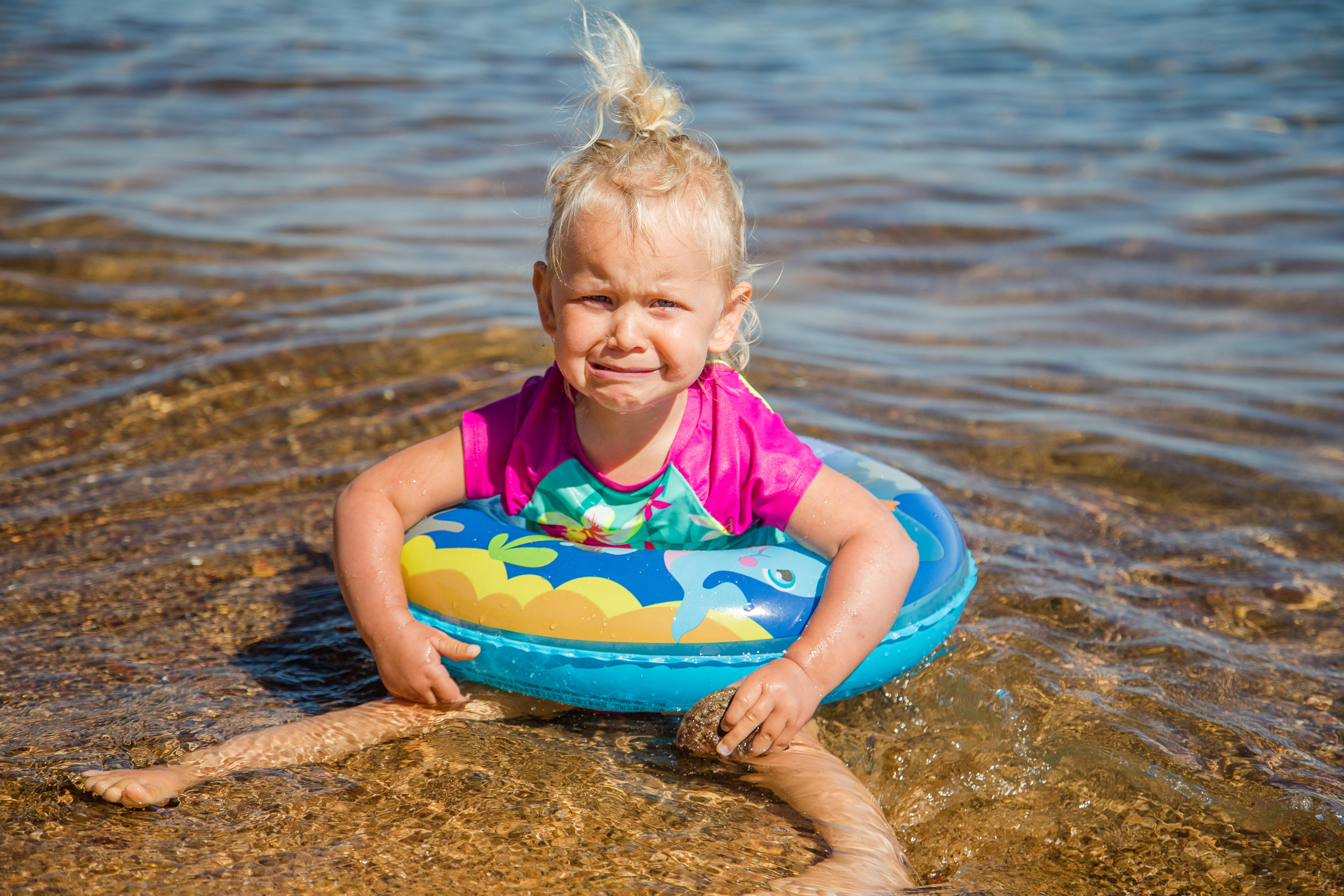 Kind in zwemband aan het water